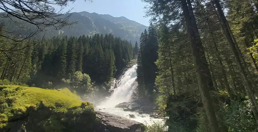 Krimmler Wasserf&auml;lle in &Ouml;sterreich zwischen B&auml;umen im Sonnenschein
