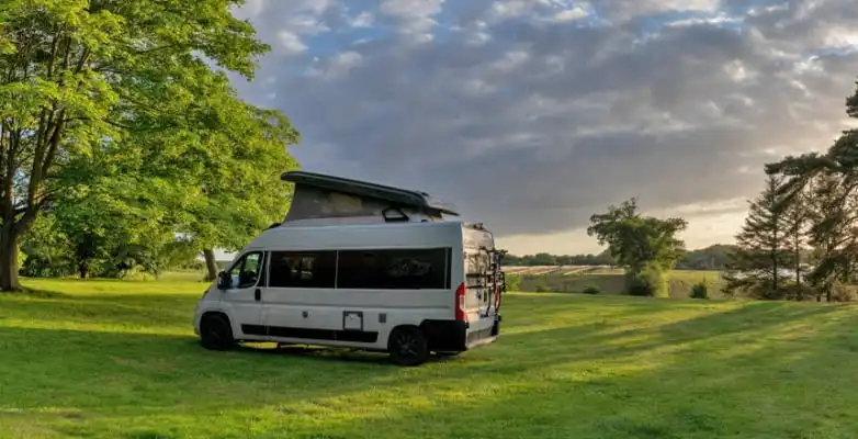 Grauer Campervan auf grüner Wiese